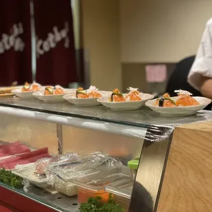 a sushi counter with bowls of sushi