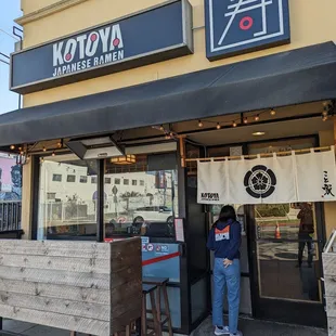 a woman standing in front of a restaurant