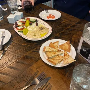 a person sitting at a table with plates of food