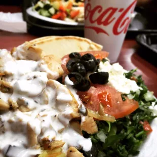 Gyro Chicken plate with mushrooms over rice topped with cucumber sauce. Side of cucumber/tabouli salad mix and pita bread