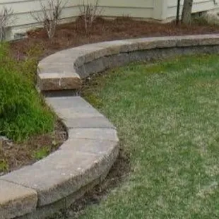 a garden with a stone wall