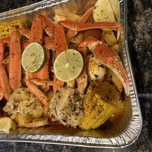 crab legs, corn, corn on the cob, and lime wedges