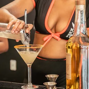 a bartender pouring a martini