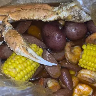 crab legs, corn, potatoes, and corn on the cob