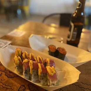 a plate of sushi and a bottle of beer