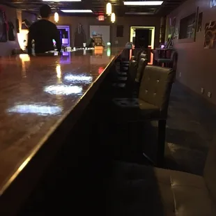 a long bar with chairs and lights