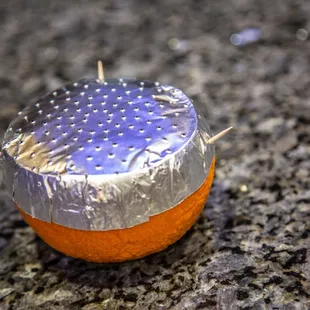 an orange wrapped in aluminum foil