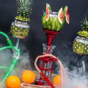 a watermelon, pineapples, and oranges