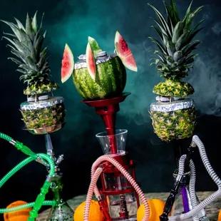 a watermelon, pineapples, and oranges