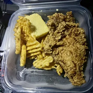 Two piece white chicken with waffle, fries, and cornbread