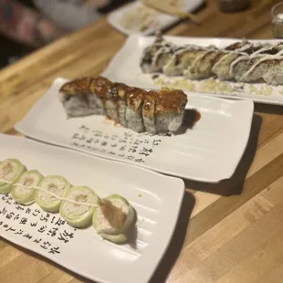 three plates of sushi on a wooden table