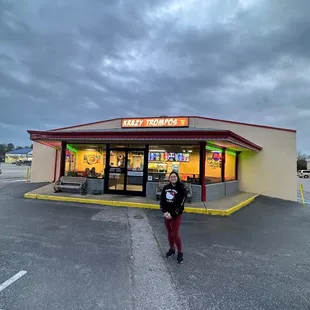 a woman standing in front of a fast food restaurant