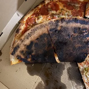 a burnt pizza in a box