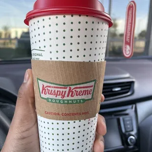 a hand holding a cup of coffee