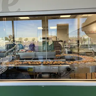 a conveyor belt filled with doughnuts