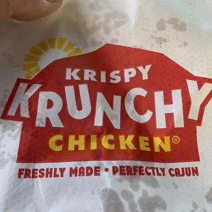 a hand holding a bag of krispy krunchy chicken