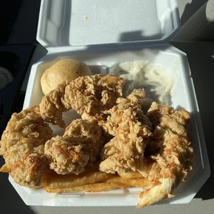 fried chicken and fries in a styrofoam container