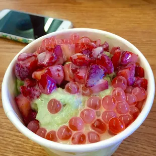 Green tea shaved ice with strawberries and strawberry boba.