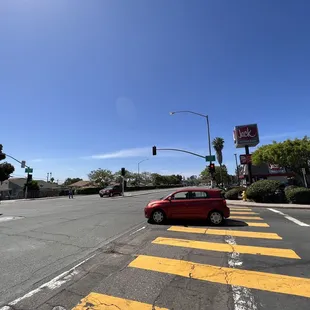 a red car driving down the street