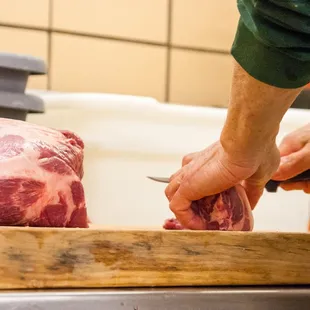 a butcher cutting a piece of meat
