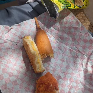 Kids lunch  half grilled cheese, half a corn dog, 1/4 slice pizza, and chips.