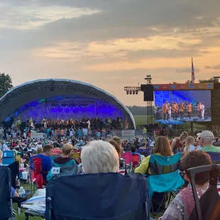 a crowd of people sitting in lawn chairs