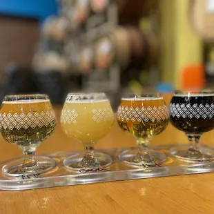 four glasses of beer on a tray