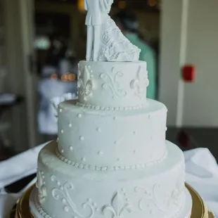 Almond-flavored wedding cake with buttercream icing and white-chocolate fleur de lis.