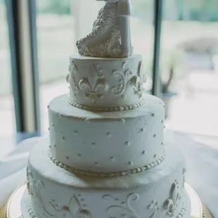 Almond-flavored wedding cake with buttercream icing and white-chocolate fleur de lis.