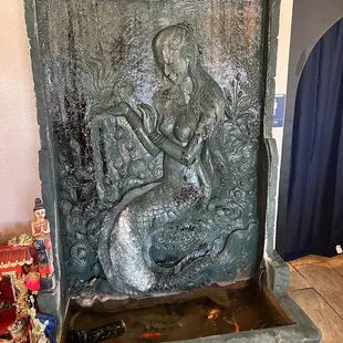 Indoor fountain with live goldfish at base.