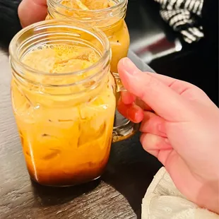 a person holding a glass of iced tea