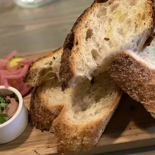 a wooden cutting board with bread and dip