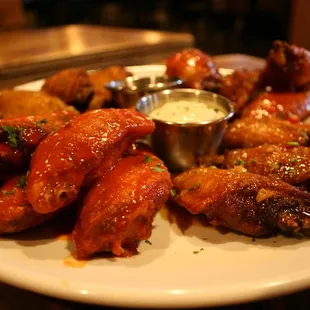 a plate of chicken wings and dipping sauce
