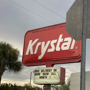 a krystal sign on a street corner