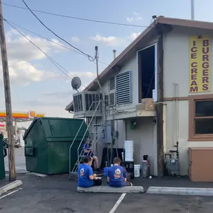 two workers working on the outside of a building