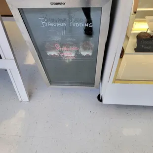 a small refrigerator with a chalkboard sign on it