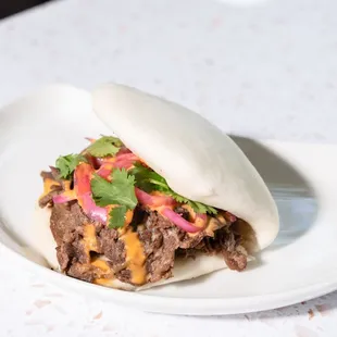 a beef sandwich on a white plate