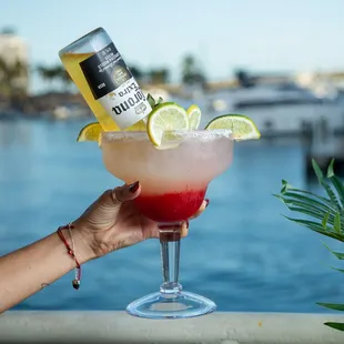 a hand holding a glass with a drink