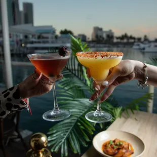 two people toasting with cocktails