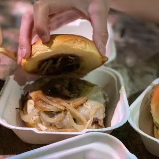 a person taking a hamburger out of a container