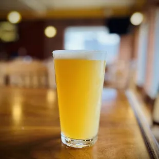 a glass of beer on a bar