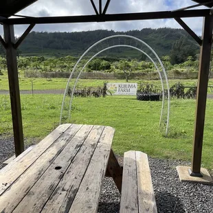 a picnic table with a sign in the background