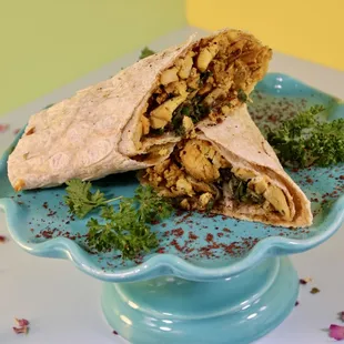 a burrito cut in half on a blue plate