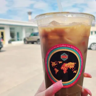 a hand holding a cup of iced coffee