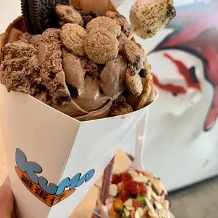 a hand holding a cup of ice cream