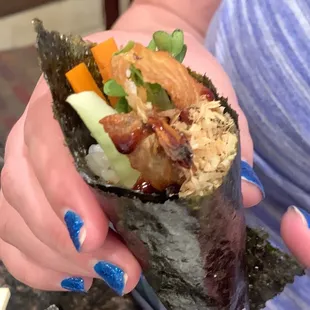 a person holding a sushi wrap