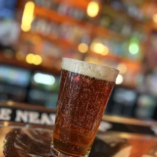 a glass of beer on a coaster
