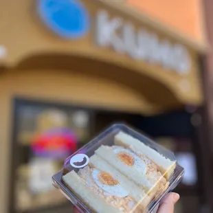 a hand holding a piece of cake