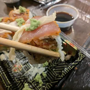 a close up of a sushi with chopsticks