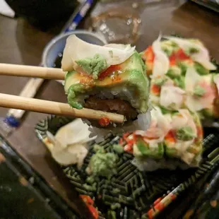 chopsticks holding a piece of sushi